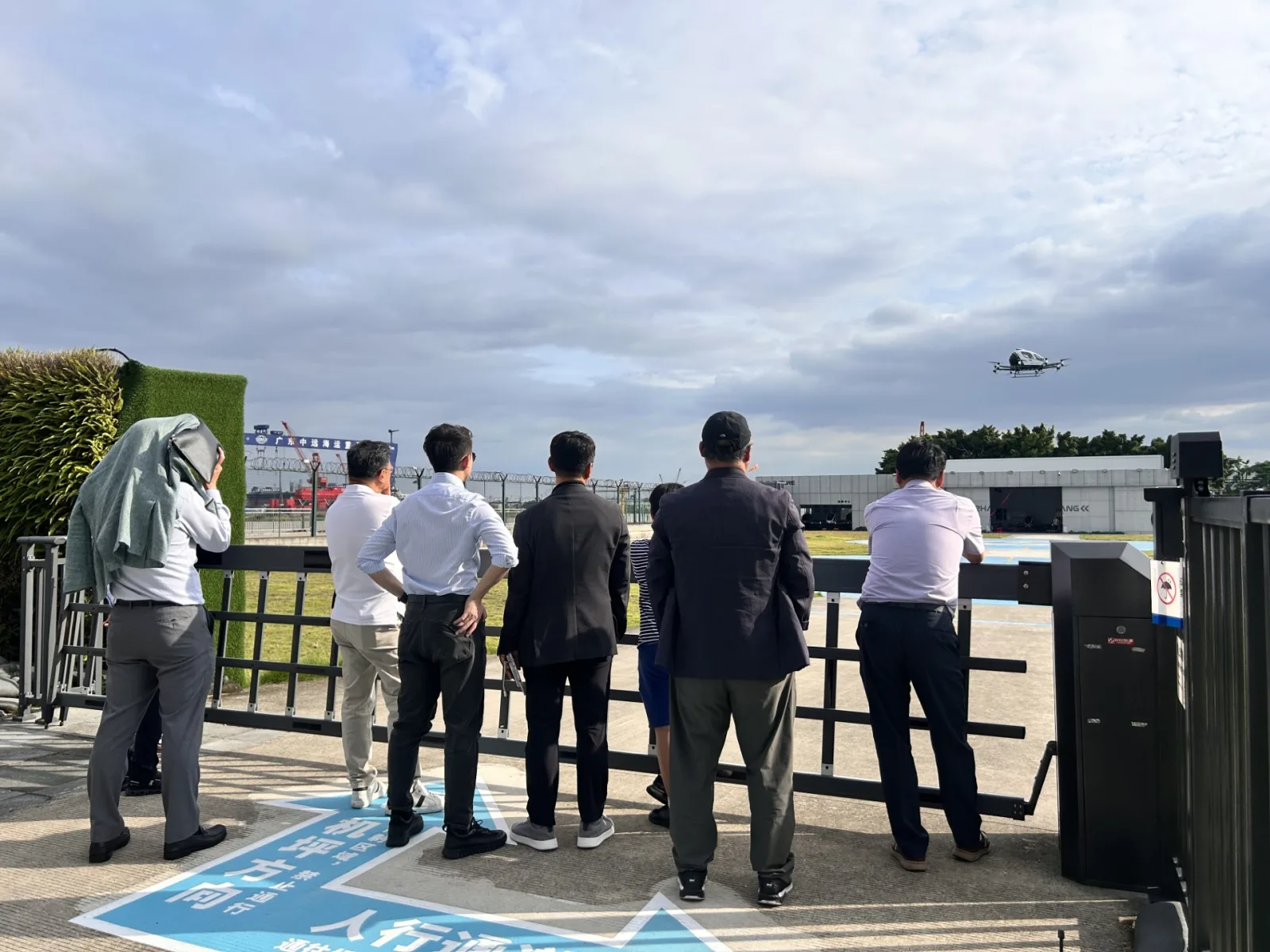 Delegation watching an EHang autonomous passenger aircraft in live flight over the test pad