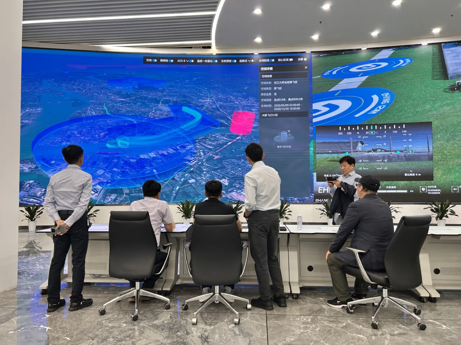 EHang integrated flight control center with a large video wall showing live flight monitoring and a city map