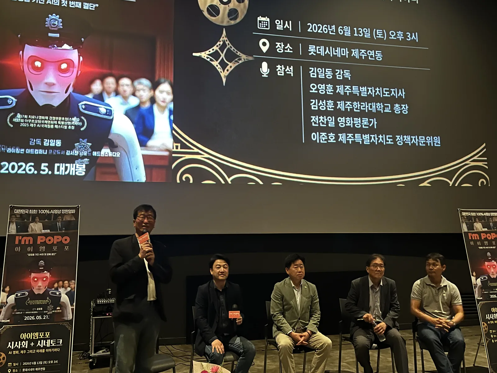 Young Joon Lee speaking during the cine-talk panel, with the panelists seated and the event slide on the screen behind them