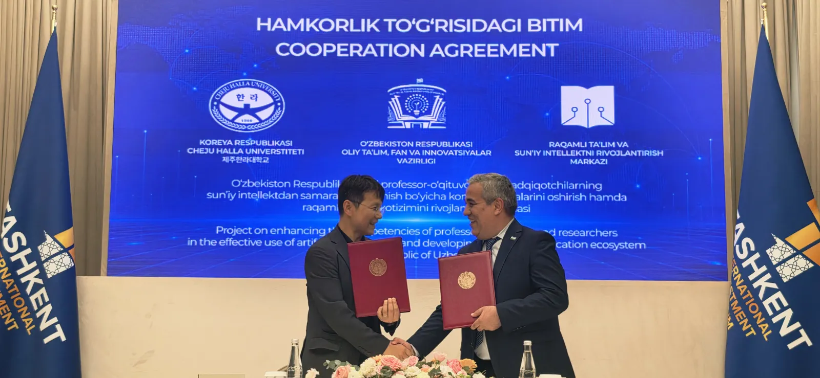 The signatories exchanging the signed agreement folders across the table